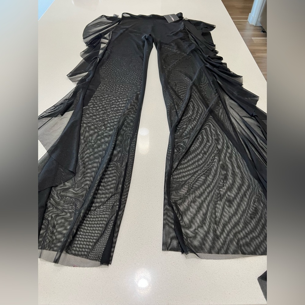Woman’s black mesh cover up pants with ruffles down the leg. Size small.